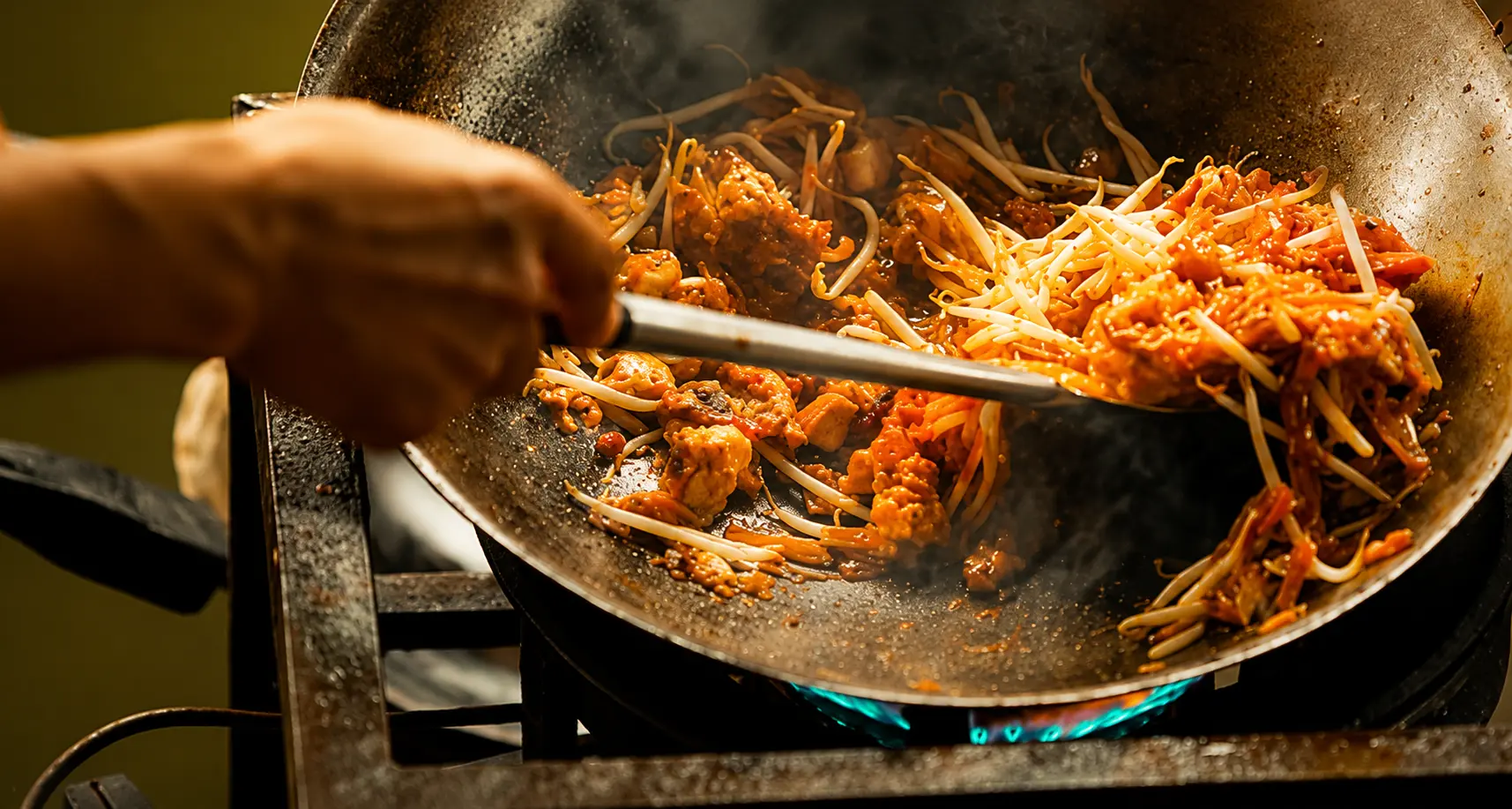 Wok med thaimat över öppen låga